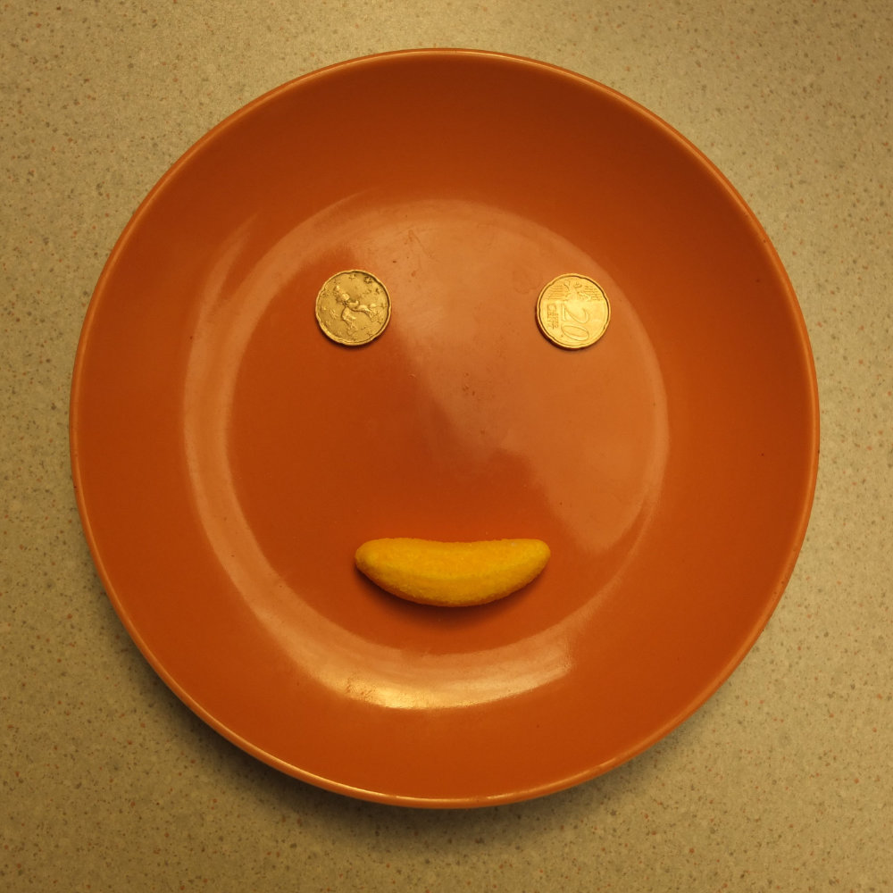 Young man with dark hair and beard, brown eyes, blue t-shirt