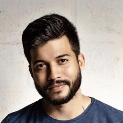 Barber 1 young man with beard smiling and wearing a brown shirt
